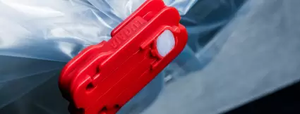 Close-up of a red Lugaia SafeSeal clamp securely sealing a single-use containment film – used for dust-tight, contamination-free closure in pharmaceutical applications.