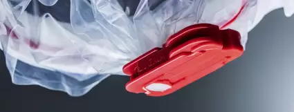Close-up of a red Lugaia SafeSeal clamp securely sealing a single-use containment film – used for dust-tight, contamination-free closure in pharmaceutical applications.