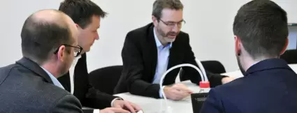 The four management board members in discussion in the meeting room