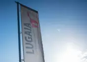 White Lugaia flags with Lugaia logo against a blue sky